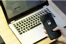 Celular com cadeado em frente ao notebook