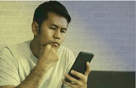 Homem desconfiado olhando o celular
